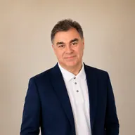 Professional portrait of Vasilis Katsoulis in a navy blazer